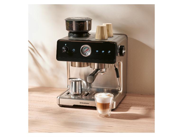 Lidl koffiemachine met melkkannetje onder de stoompijp en een glas latte macchiato op het aanrecht